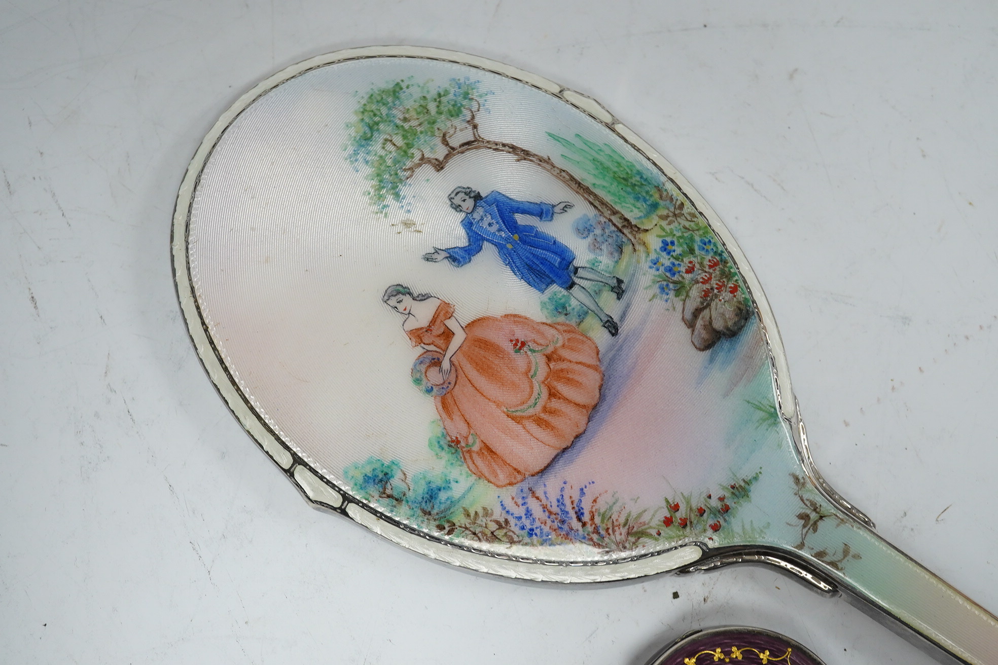 A George VI silver and enamelled hand mirror, by Daniel Manufacturing Company, Birmingham, 1947, 28.3cm, together with a Scandinavian 925 and enamel circular pill box. Condition - fair